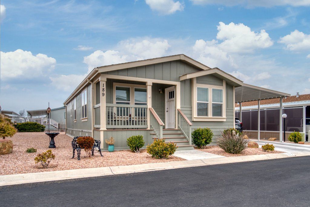 A spacious double wide manufactured home with a well-maintained front yard, showcasing the open layout and residential appeal typical of double wide homes.