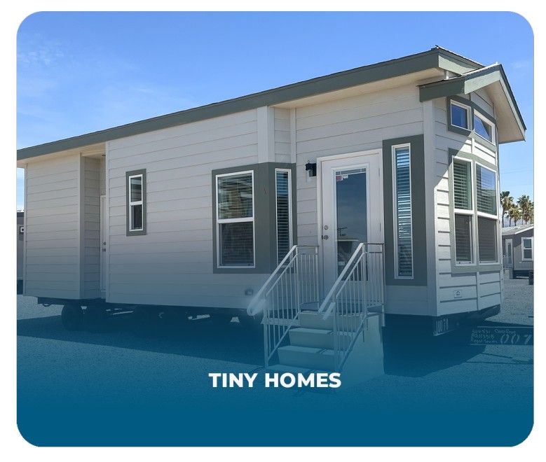 Compact Tiny Home on wheels with white siding and elevated steps, affordable and low-maintenance small home option.